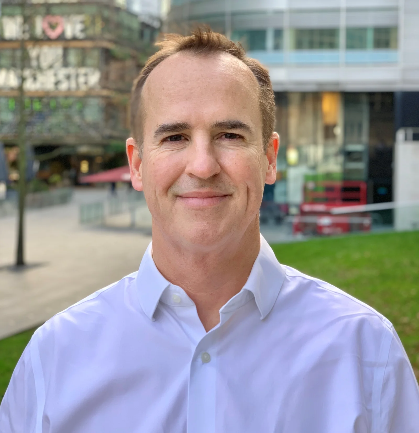 Brian Westley, leadership and executive coach, standing outdoors in Manchester in a light blue shirt